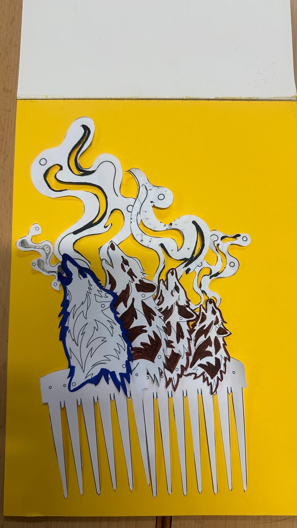 Maqueta sobre fondo amarillo con siluetas de lobos, vaho y dientes de la peineta